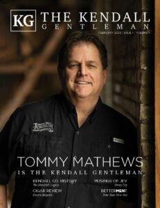 Tommy Mathews on the cover of The Kendall Gentleman February 2025 issue, wearing a Tusculum Brewing Co. shirt, standing against a rustic backdrop.