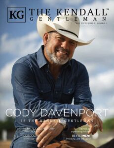Cody Davenport wearing a cowboy hat and denim shirt, smiling on the cover of The Kendall Gentleman July 2025 issue.
