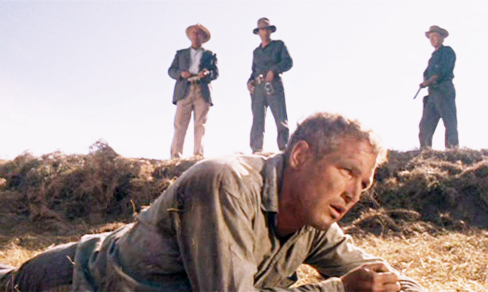 Paul Newman As Luke Lies Beaten but Unbroken in the Dirt, with Prison Guards Watching from Above in a Scene from Cool Hand Luke.