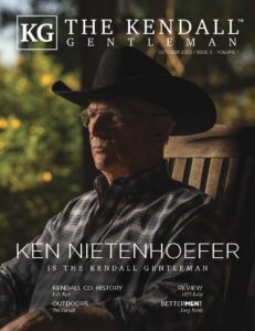 Ken Nietenhoefer on the October 2025 cover of The Kendall Gentleman magazine, wearing a cowboy hat and plaid shirt while seated outdoors.