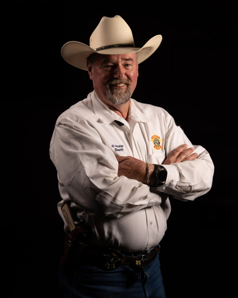 Kendall County Sheriff Al Auxier Stands Confidently with Arms Crossed, Wearing His Uniform and Cowboy Hat, Symbolizing Faith and Servant Leadership.