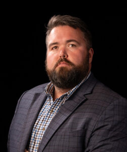 Michael G. Ethridge, publisher of The Kendall Gentleman, photographed against a black background for his December 2025 editorial, “The Standard We Keep.”