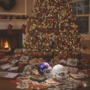 Christmas tree with gifts and two football helmets beneath it, symbolizing childhood memories, family, and the meaning of Christmas.