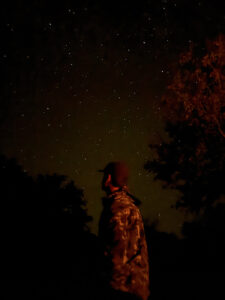 Hunter Mazour standing beneath a star-filled night sky along the Devils River in Texas