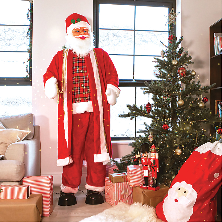 Life-size Santa Claus Decoration Standing Beside a Decorated Christmas Tree and Wrapped Presents in a Cozy Living Room.