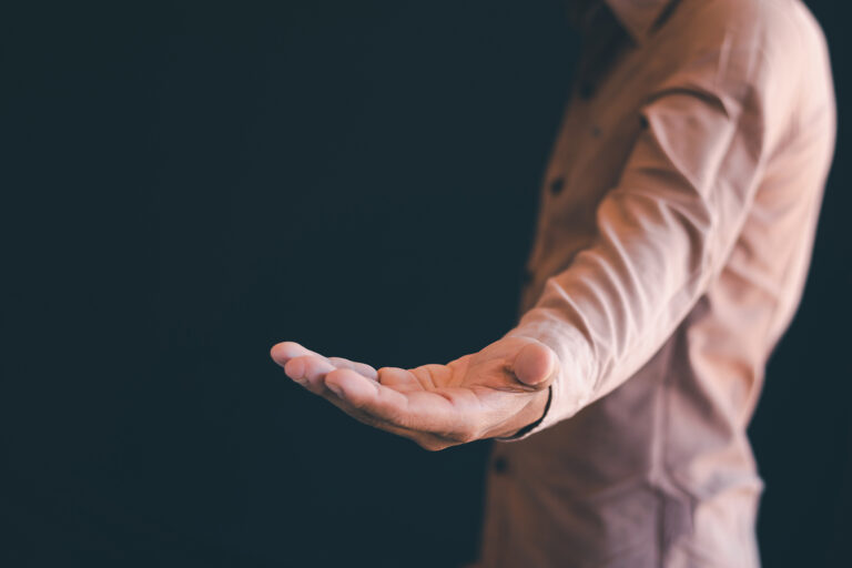 An outstretched hand symbolizing quiet strength, vulnerability, and healthy interdependence among men