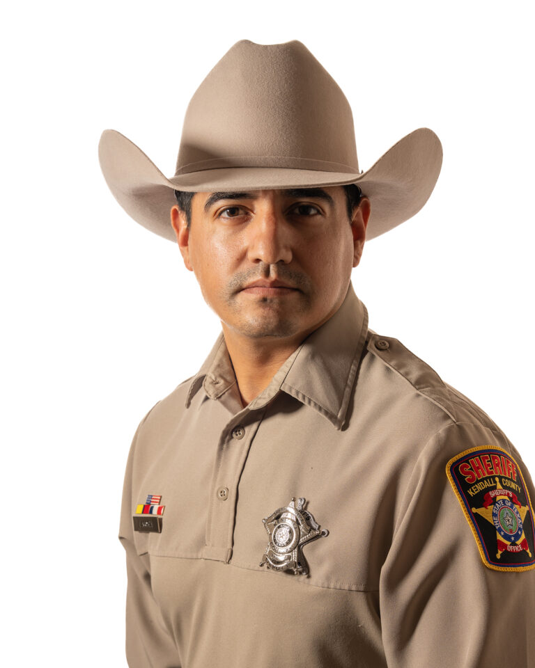 Officer Juan Acosta of the Kendall County Sheriff’s Office wearing his uniform and cowboy hat against a white background.