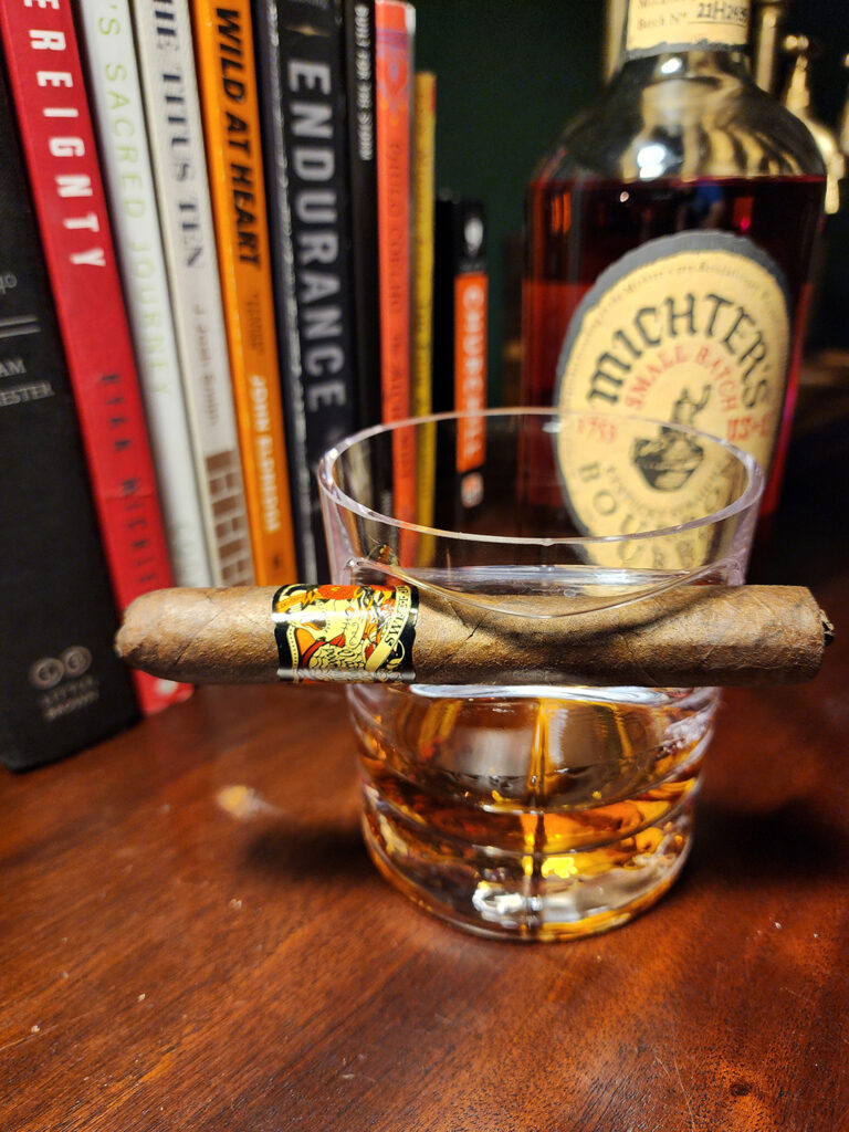 Deadwood Sweet Jane cigar resting on a glass of Michter’s Small Batch Bourbon during a February cigar review