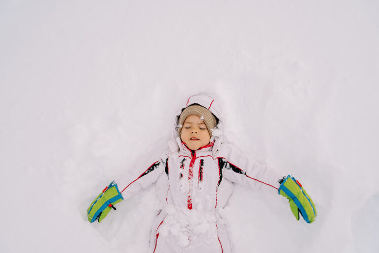 Child making a snow angel, reflecting the innocence and memory at the heart of “The Snow Story.”