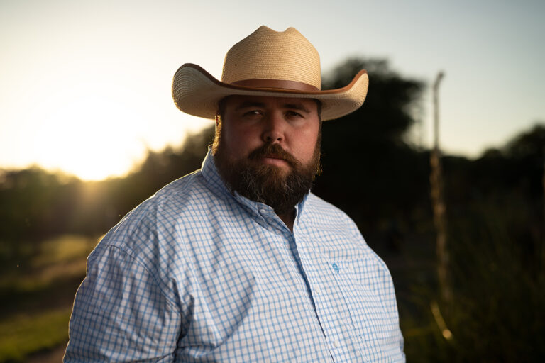 Portrait of the Kendall Gentleman Publisher Standing Outdoors in the Texas Hill Country at Sunset Wearing a Cowboy Hat
