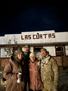 Group of hunters standing outside Las Cuatas ranch building during a hunting trip in Texas.