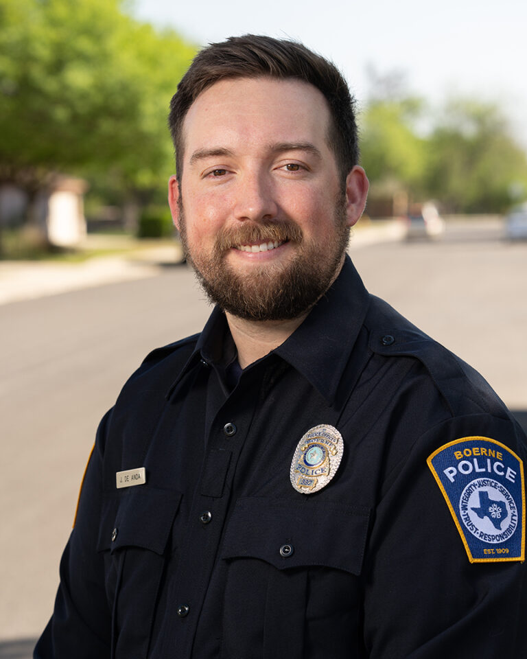 Officer Jacob De Anda of the Boerne Police Department Standing in Uniform on a Residential Street in Boerne, Texas