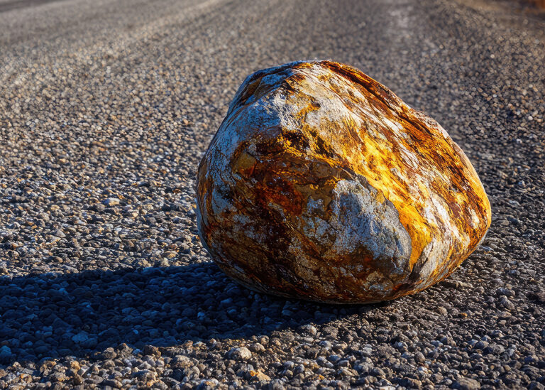 Large Stone Resting in the Middle of a Road Symbolizing Life’s Obstacles, Faith, and Perseverance