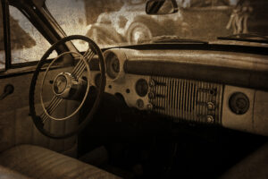 Sepia-toned interior of a vintage Buick automobile with worn dashboard and steering wheel, evoking memories of early Boerne, Texas and small-town life in Kendall County.