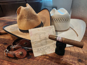 Los Vista Cigars' The '64 robusto resting on a torch lighter beside cowboy hats and spurs, Boerne, Texas
