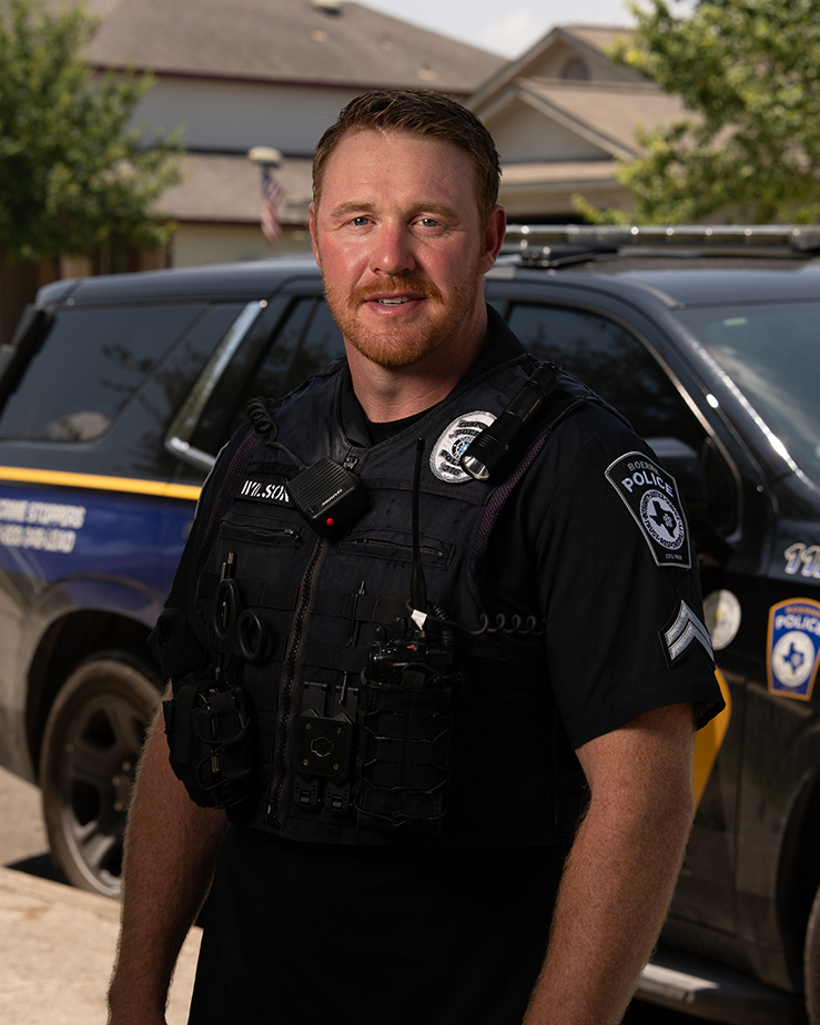 Boerne Police Officer Jeffrey Wilson Standing in Front of His Patrol Vehicle