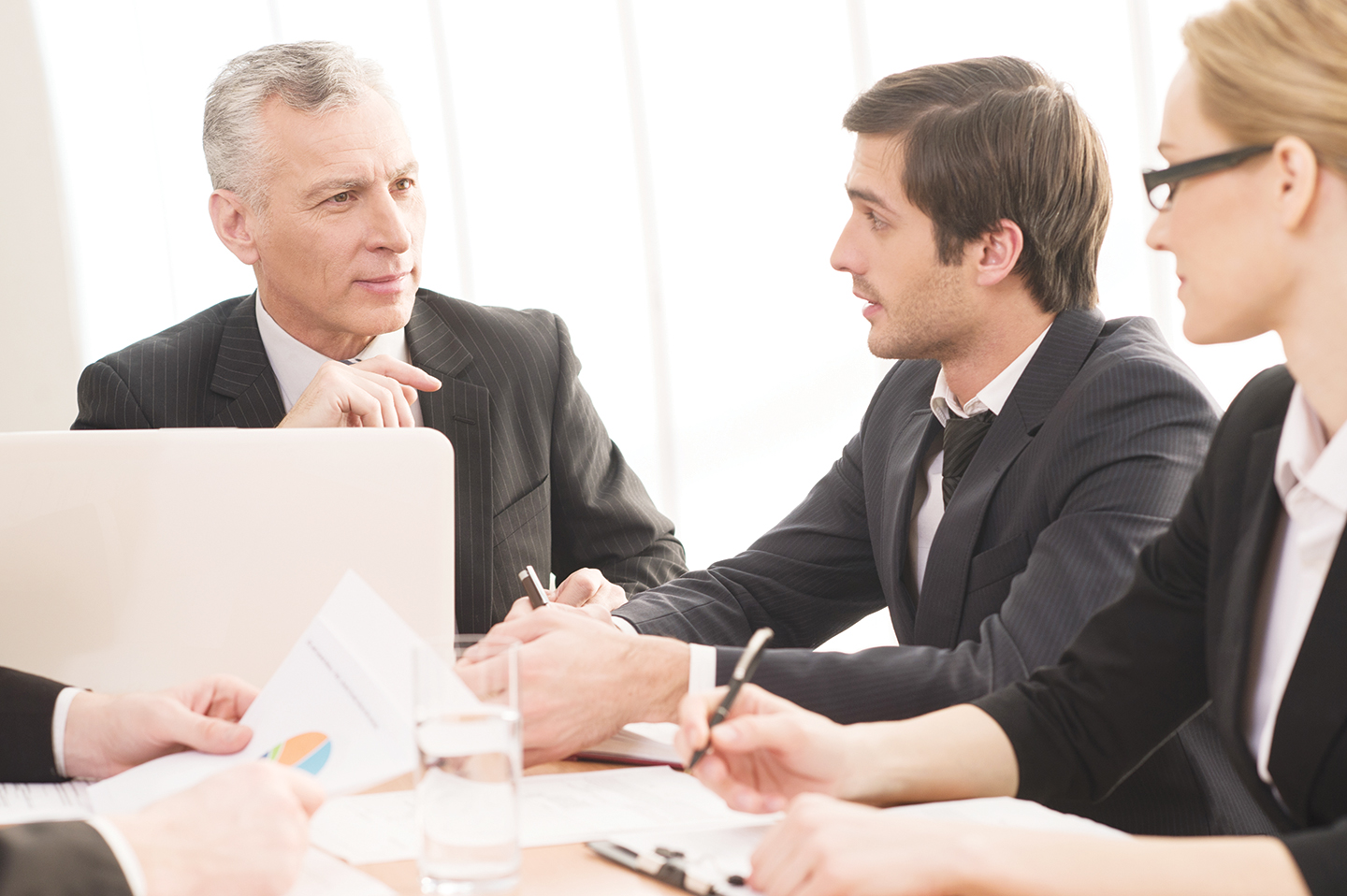 Business People in Formalwear Seated Together at a Meeting Table