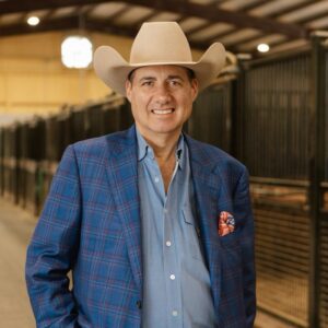 Frank Addington in a Cowboy Hat and Blue Plaid Blazer in a Horse Barn