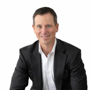 Sam Mcgee in a Dark Suit and White Shirt