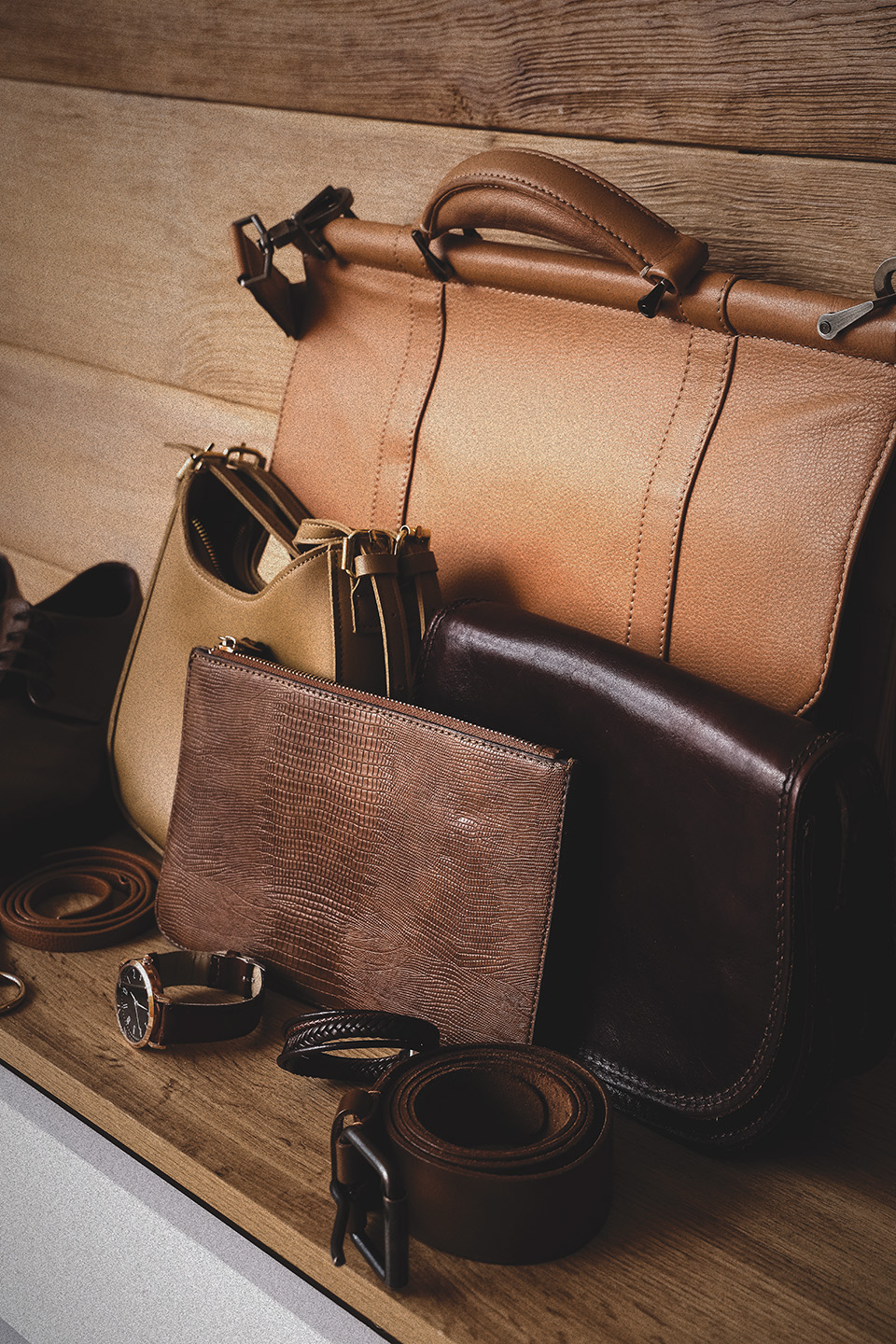 Brown Leather Belts, Handbags and Wallets Arranged on a Wooden Surface